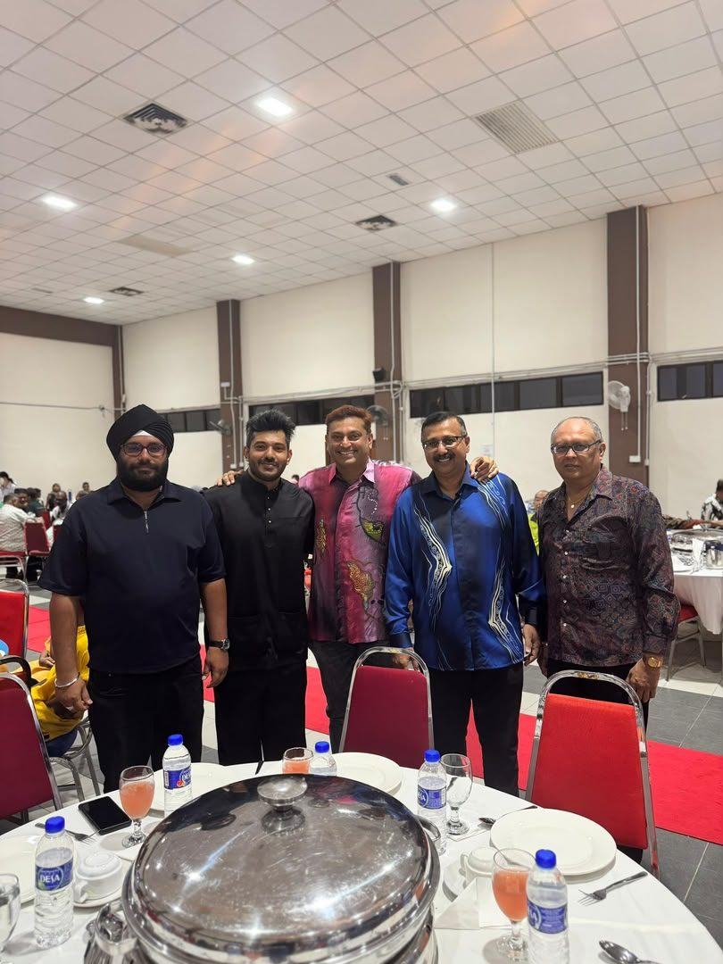 Five men posing together at a community dinner